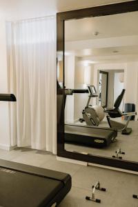 a mirror in a gym with exercise equipment in it at The Pure, Frankfurt, a Member of Design Hotels in Frankfurt/Main