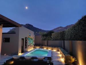 a backyard with a swimming pool and a house at 1 On Royal in Cape Town