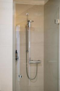 een douche in een badkamer met een glazen deur bij The Pure, Frankfurt, a Member of Design Hotels in Frankfurt am Main