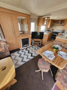 a living room with a table and a kitchen at Eastgate Fantasy Islands Static Caravan Park in Ingoldmells