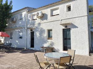 a patio with a table and chairs in front of a building at Casa Mas Montañas - Gris in Godelleta