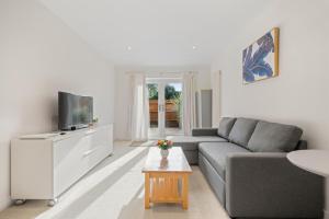 a living room with a couch and a tv at Molesey Apartments in East Molesey