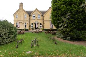 uma casa com mesas de piquenique e cadeiras no quintal em The Finch Hatton Arms em Sleaford