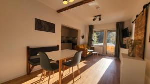 een keuken en een woonkamer met een tafel en stoelen bij Ferienwohnung Berglodge 11 Hahnenklee Bockswiese in Goslar