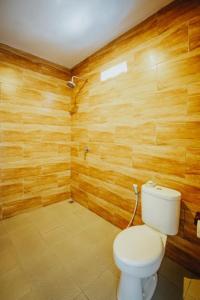 a bathroom with a toilet and wooden walls at Pondok Kita in Canggu