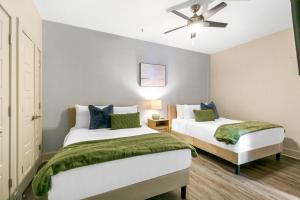 a bedroom with two beds and a ceiling fan at Steps to French Quarter Rooftop & Gym Sleeps 12 in New Orleans