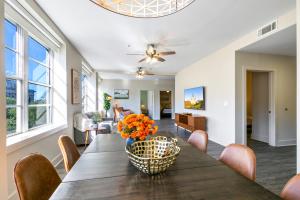 a dining room table with chairs and a vase of flowers at Steps to French Quarter Rooftop & Gym Sleeps 12 in New Orleans +38 photos