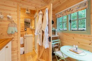 ein Badezimmer aus einer Blockhütte mit einem Tisch und einem Waschbecken in der Unterkunft Shepherds Hut with Hot Tub 