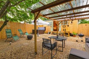 a patio with chairs and a table under a pergola at Shepherds Hut with Hot Tub 