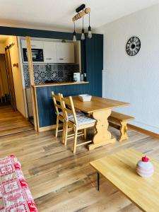 uma cozinha e sala de jantar com uma mesa de madeira e cadeiras em Magnifique studio 4 pers avec balcon vue montagne em Orcières