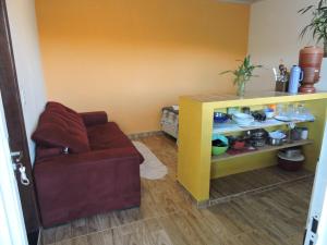 a living room with a couch and a shelf with dishes at Casa de Campo Chalé Saturno in Alto Paraíso de Goiás