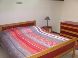 a bedroom with a bed with a wooden frame and a dresser at Au Songe Du Valier- Appartements in Seix