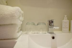 Un baño con lavabo con dos vasos. en Grimisdale Guest House en Leverburgh