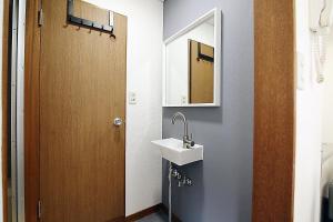 La salle de bains est pourvue d'un lavabo et d'un miroir. dans l'établissement SUNRISE, à Tokyo