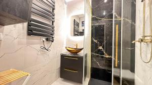 uma casa de banho com chuveiro e uma tigela no balcão em Apartament Złoty w Opolu em Opole
