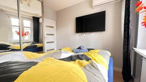 sypialnia z dwoma łóżkami i telewizorem na ścianie w obiekcie Apartament Złoty w Opolu w mieście Opole