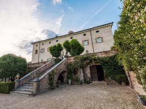een oud gebouw met trappen en klimop bij Castello di Coazzolo in Neive