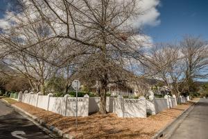 a tree in front of a white fence at The Corner House L'A-nnexe in Franschhoek
