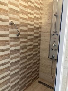 a bathroom with a shower with a wooden wall at Center Piac Aparman in Debrecen