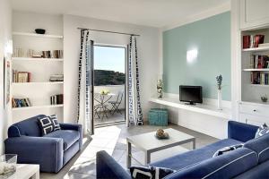 Sala de estar con 2 sofás azules y TV en Le Capannelle, en SantʼAgata sui Due Golfi