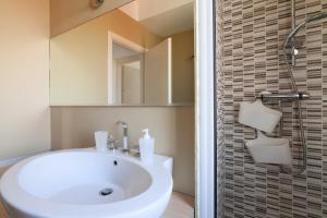 a bathroom with a white sink and a shower at PrimoPiano - Carlone in Milan