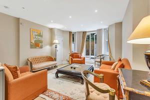 a living room with orange furniture and a table at Beautiful Abode in Kensington Olympia in London