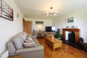 een woonkamer met een bank en een tv bij Cloyfin B and B in Coleraine