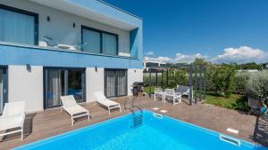 a villa with a swimming pool and a house at Villa Chic by Villas Holiday in Umag