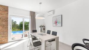 a white dining room with a white table and chairs at Villa Chic by Villas Holiday in Umag