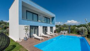 a villa with a swimming pool in front of a house at Villa Chic by Villas Holiday in Umag