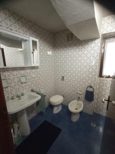 a bathroom with a white toilet and a sink at LakyFamily in Cogolo