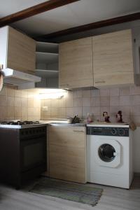 a kitchen with a washing machine and a stove at LakyFamily in Cogolo