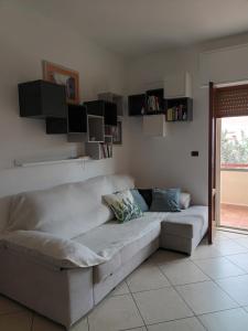 ein weißes Sofa im Wohnzimmer mit Fenster in der Unterkunft CASA LIDIA in Bari