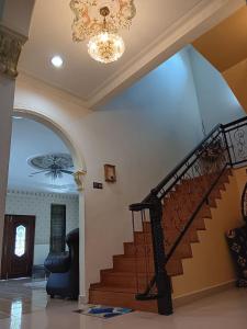 a staircase in a house with a chandelier at Homestay Banglo Alor Setar in Alor Setar