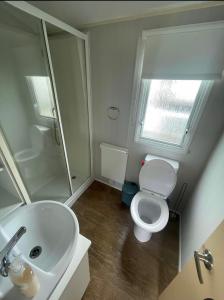 a bathroom with a white toilet and a sink at Lyon’s Robin Hood Rhyl caravan sbw in Rhyl +8 photos