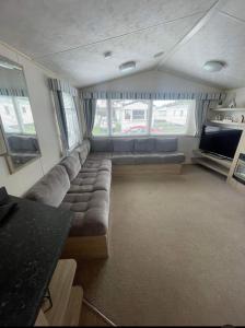 a living room with a couch and a tv at Lyon’s Robin Hood Rhyl caravan sbw in Rhyl