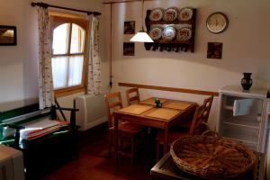 MagyarszombatfaにあるAnna Lakのテーブルと椅子、壁に時計が備わる客室です。