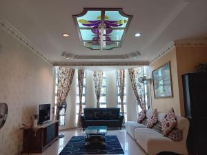 a living room with a couch and a stained glass window at Homestay Banglo Alor Setar in Alor Setar