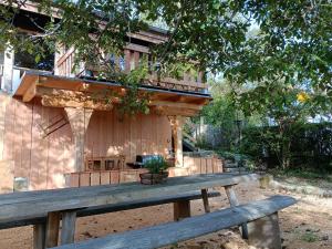 a wooden bench in front of a building with a deck at Ferienhaus am Bückeberg in Gernrode - Harz