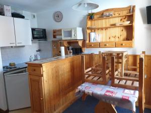 a kitchen with wooden cabinets and a counter top at ski-in ski-out 108 in Val Thorens