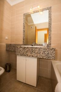La salle de bains est pourvue d'un lavabo et d'un miroir. dans l'établissement Tranquility Apartment, à Caniço
