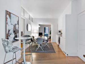 una cucina e una sala da pranzo con tavolo e sedie di Sanders Leaves - Charming Three-Bedroom Apartment In Downtown Copenhagen a Copenaghen