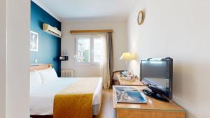 een hotelkamer met een bed en een flatscreen-tv bij Lucy Hotel in Chalkida