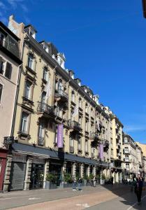 史特拉斯堡的住宿－斯特拉斯堡中心小法國美居酒店，街道上带紫色阳台的大型建筑