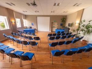 an empty room with blue chairs and a whiteboard at Grant Arms Hotel in Grantown on Spey