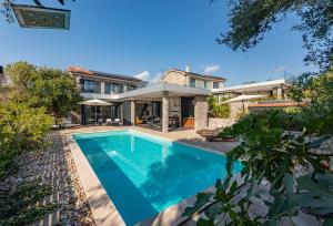 eine Außenansicht eines Hauses mit Swimmingpool in der Unterkunft Vila Coratina ZadarVillas in Jakišnica