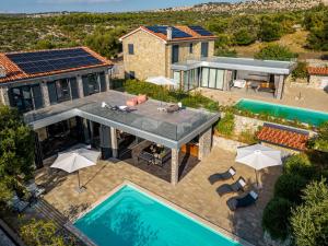 eine Luftaufnahme eines Hauses mit Swimmingpool in der Unterkunft Vila Coratina ZadarVillas in Jakišnica