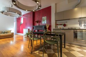 cocina con paredes rojas, mesa negra y sillas en Oasis Rome Centre Apartment, en Roma
