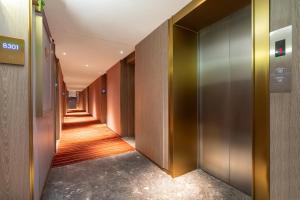 un pasillo con puertas metálicas y un pasillo largo en 宜尚Plus酒店广州北京路步行街店, en Guangzhou