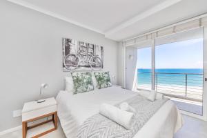 a bedroom with a large bed with a view of the ocean at Horizon Bay 702 in Bloubergstrand